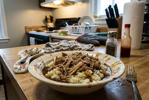 Shredded crockpot chicken and gravy served over mashed potatoes