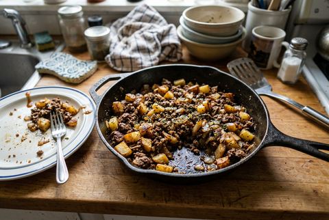 Ground beef and crispy potatoes skillet with onions and herbs